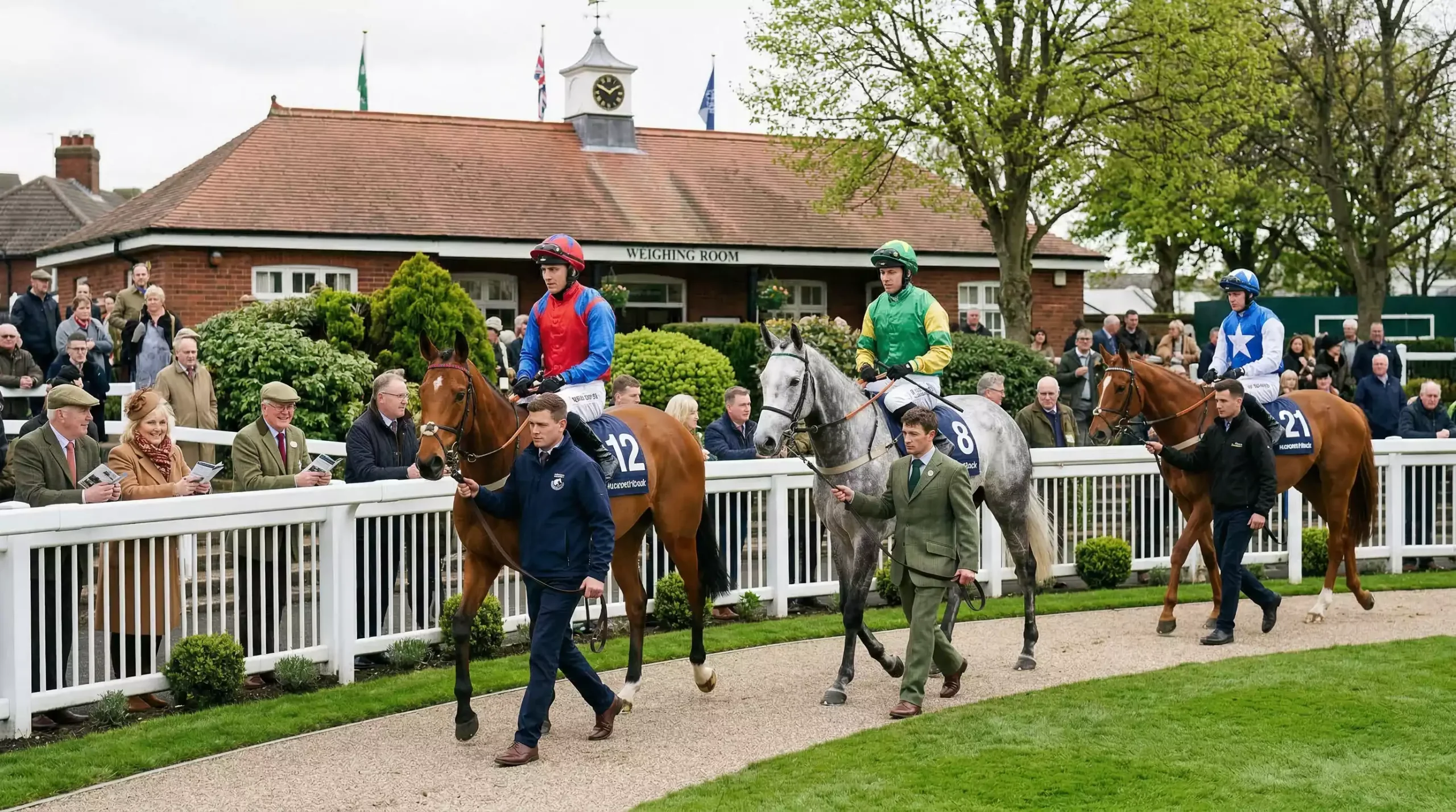 Horses and jockeys in the Aintree parade ring before the Grand National race